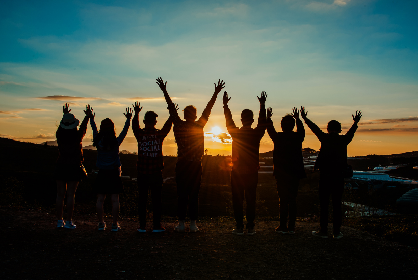 People standing together raising their hands at sunrise - Michelle Barringer